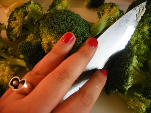 Elizabeth cutting broccoli for her broccoli soup!